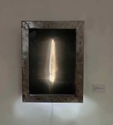 The metal lightbox mounted on a wall, lit from within.