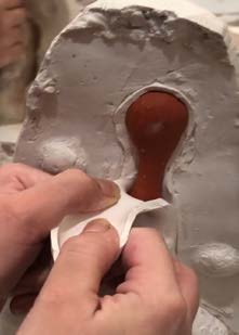 The wax model being carved before casting.